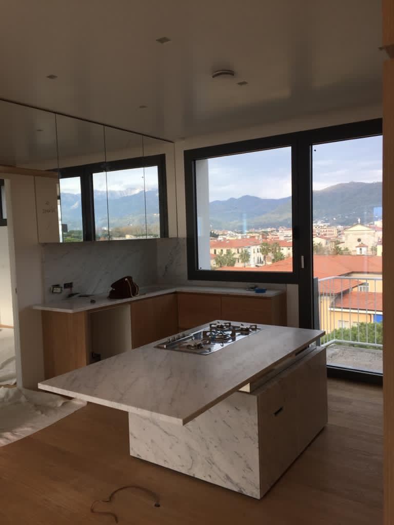 L'isola in marmo vista di scorcio, con la vetrata e le colline sullo sfondo