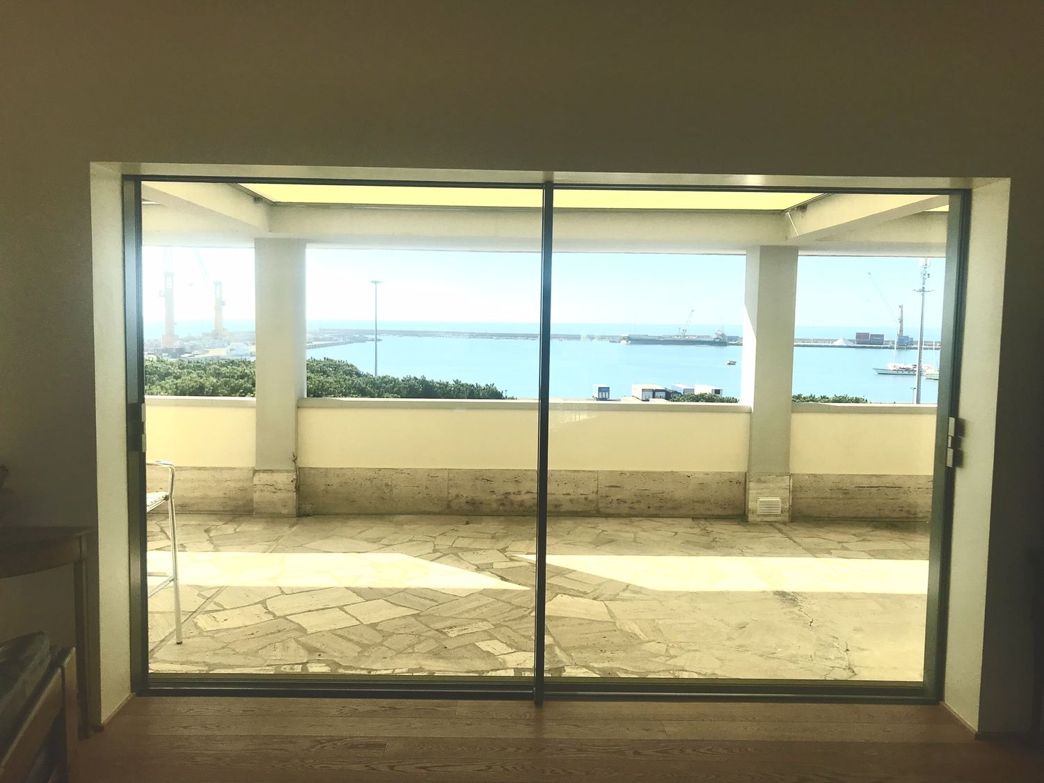 Febbraio 2022: la terrazza ormai vetrata, con la grande apertura che inquadra il mare, il porto e il pontile