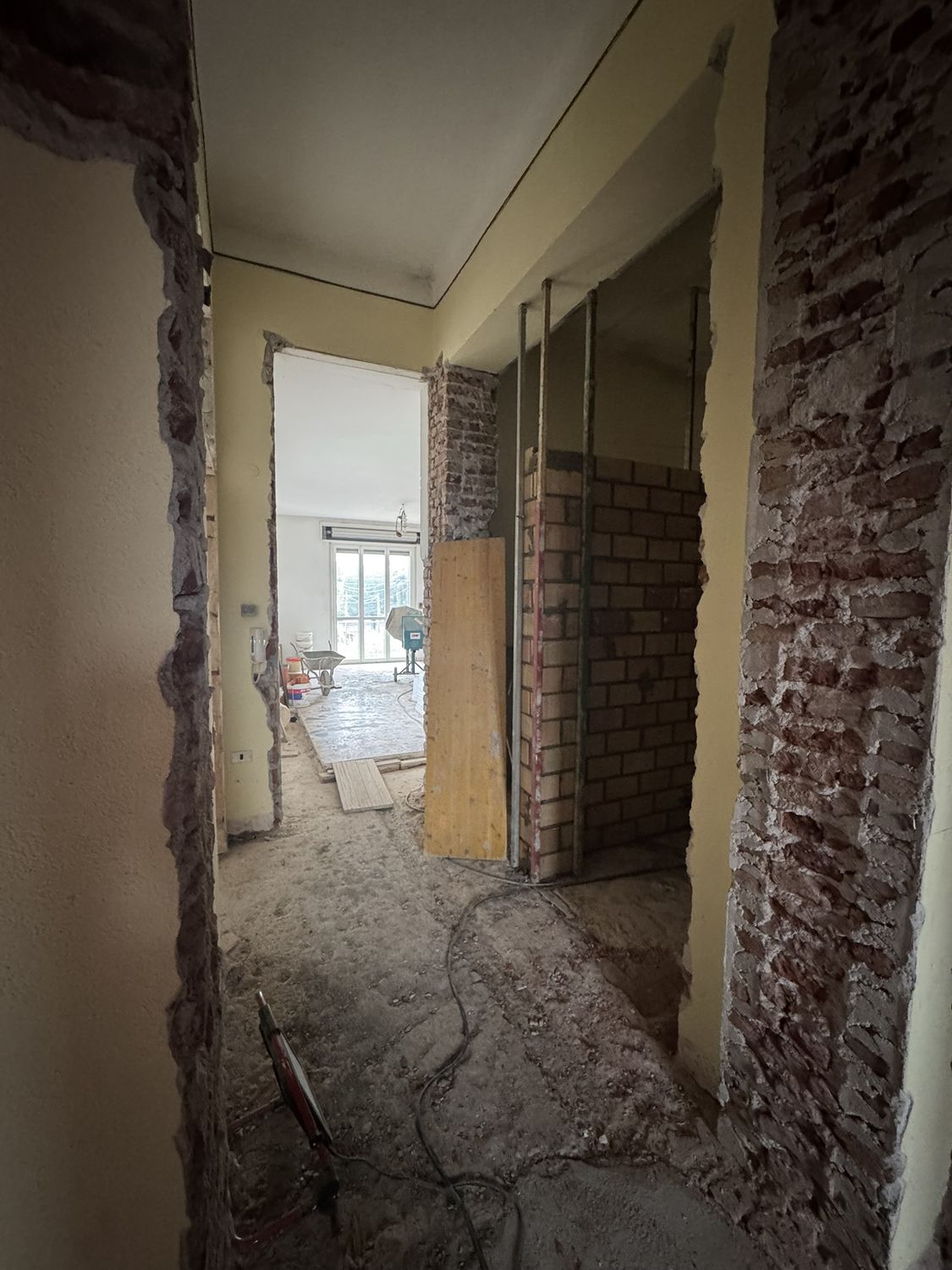 Cantiere: l'infilata delle stanze con i muri aperti e la luce che arriva dal fondo