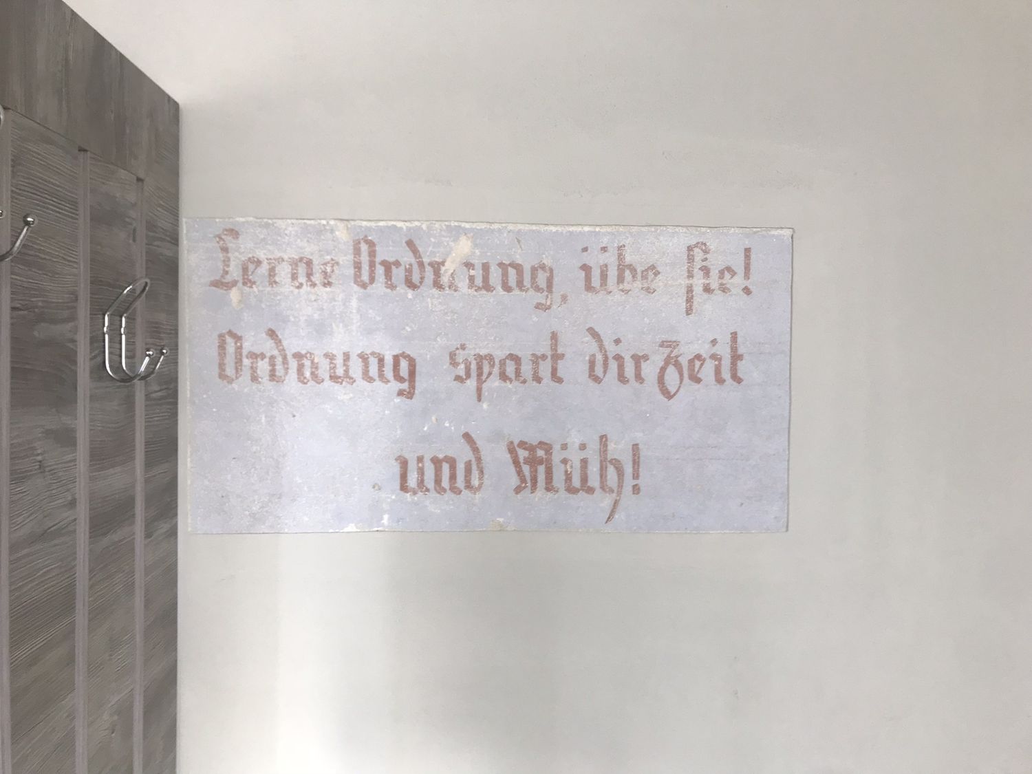 Una scritta in tedesco dipinta su un muro interno: Lerne Ordnung, &uuml;be sie! Ordnung spart dir Zeit und M&uuml;h