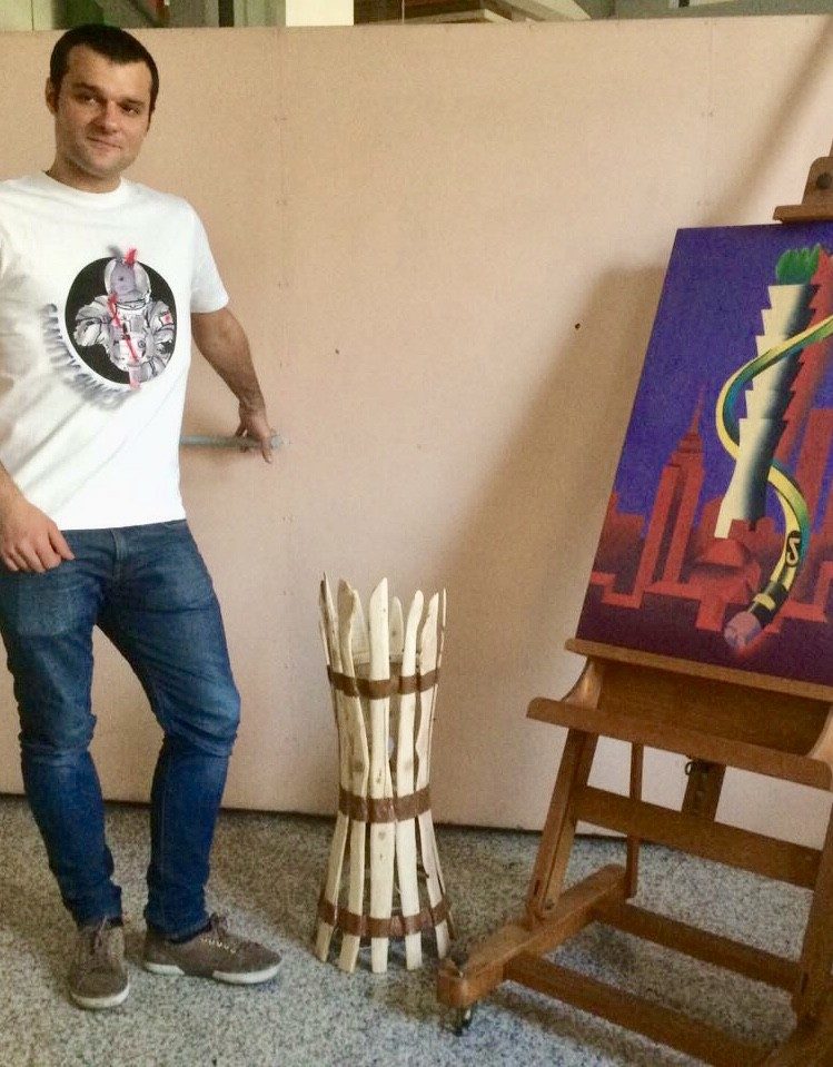 Matteo Gardino in piedi accanto alla lampada in ginepro, per la scala