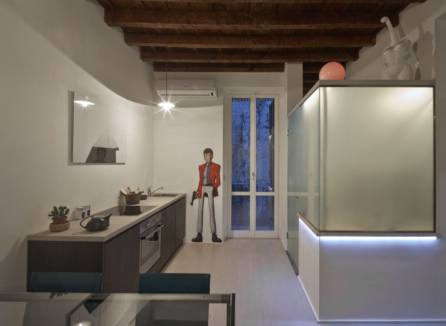 La cucina lineare e il volume in vetro acidato del bagno