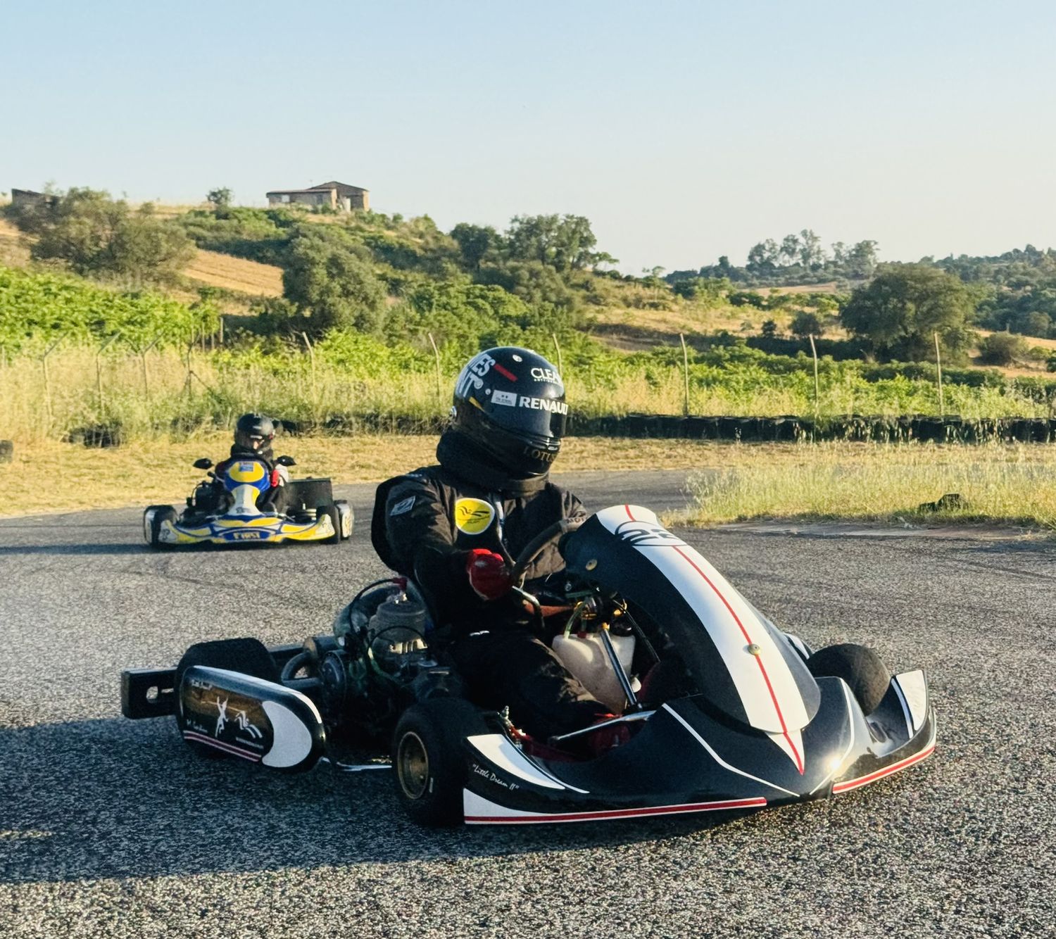 Il kart in movimento su un circuito fra le colline, con Matteo Gardino al volante e il casco nero