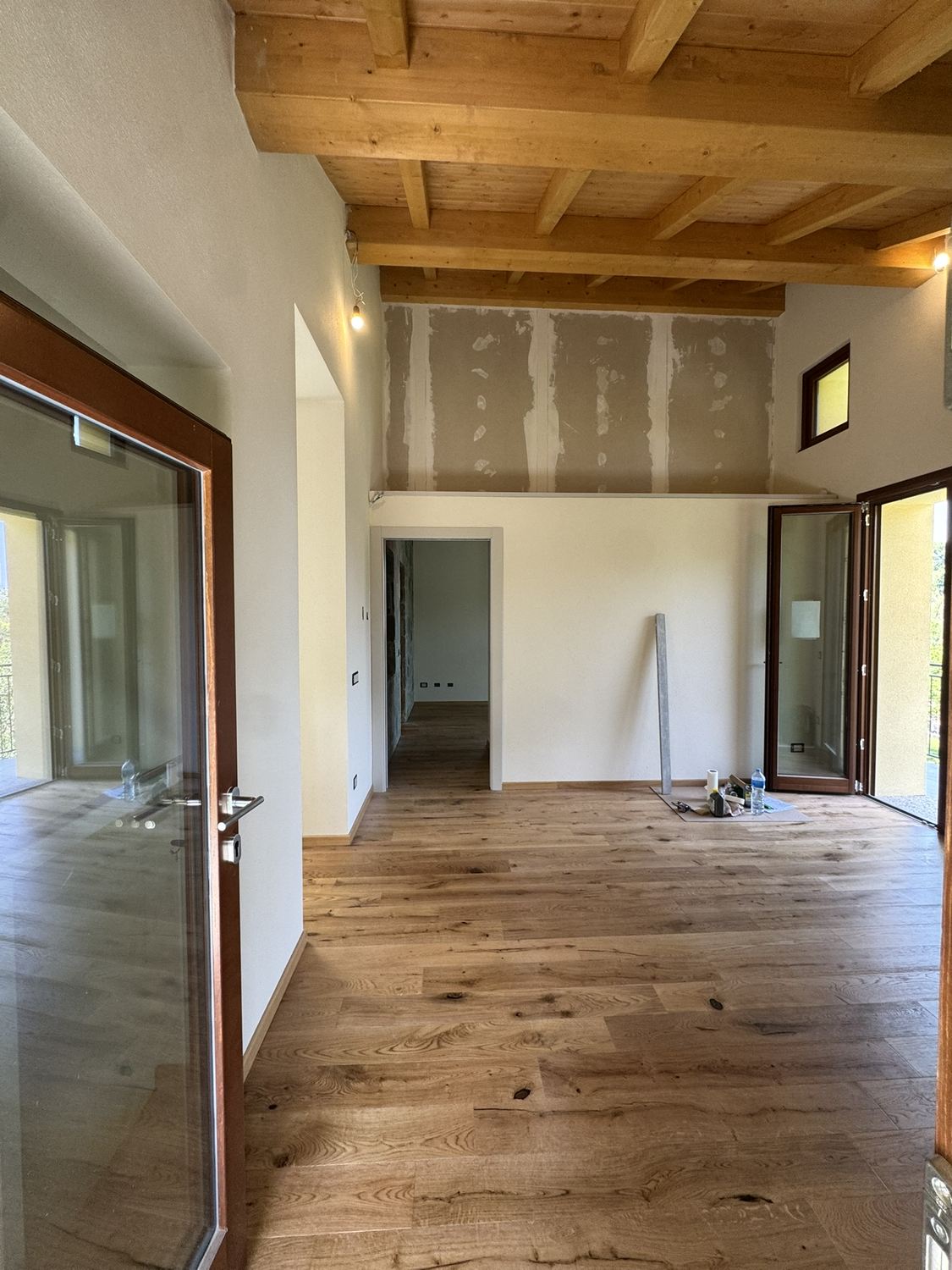 Il soggiorno in agosto: sopra il muro basso c'&egrave; ancora il cartongesso grezzo, con gli stucchi a vista