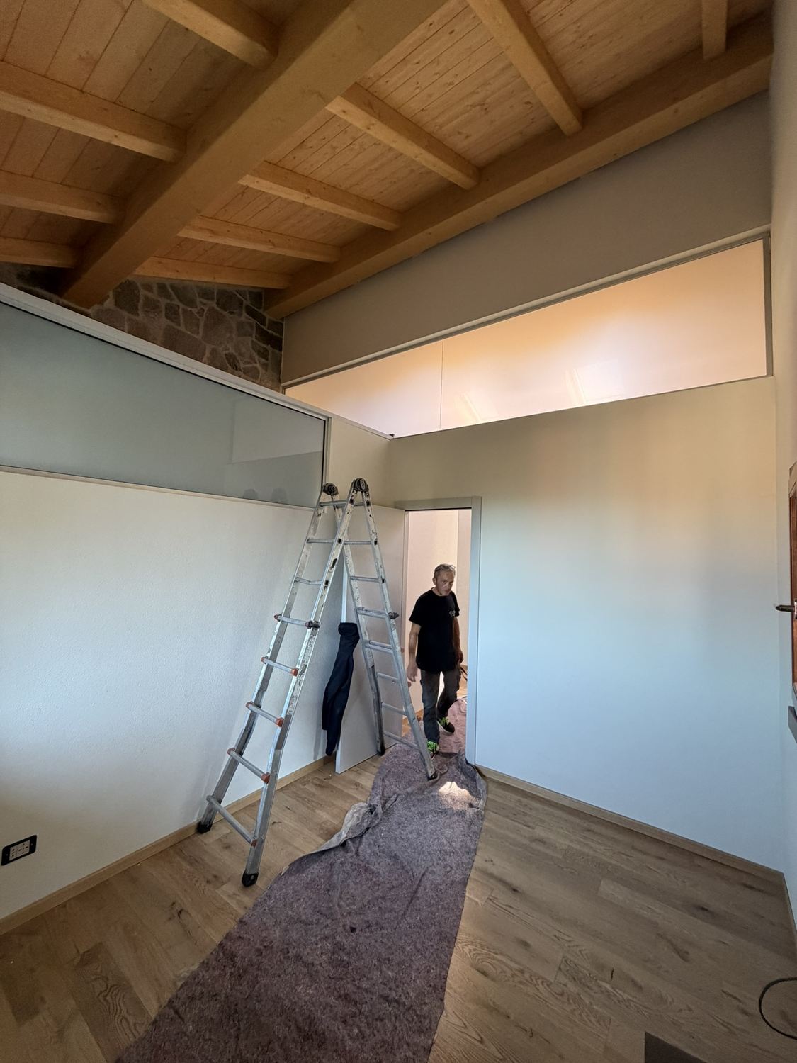 La camera degli ospiti: sopra il muro basso corre il vetro accoppiato bianco latte; in alto si vede il muro in pietra sopra il bagno della camera principale