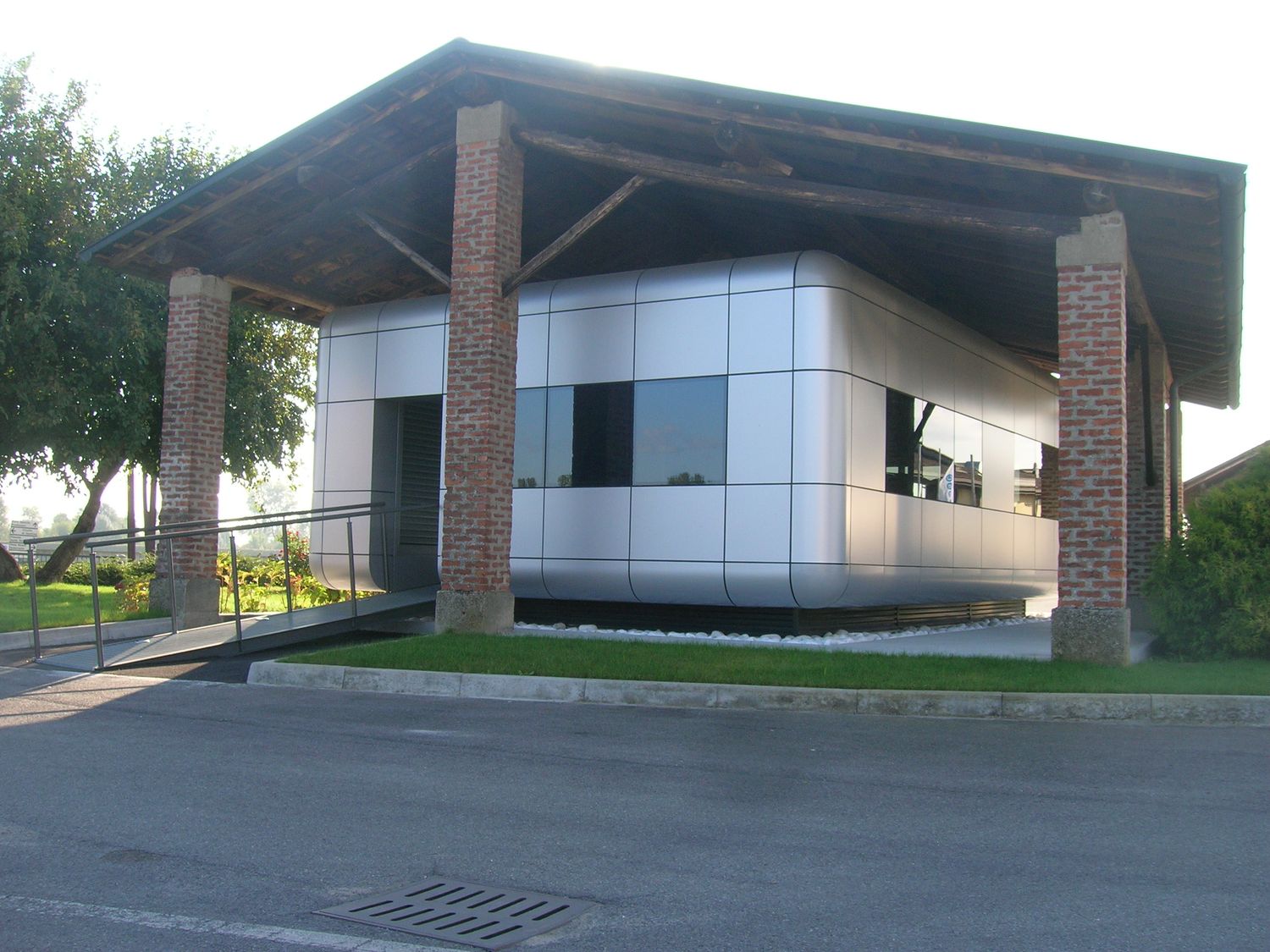 La reception di tre quarti, con la rampa d'accesso e i pilastri in mattone della tettoia